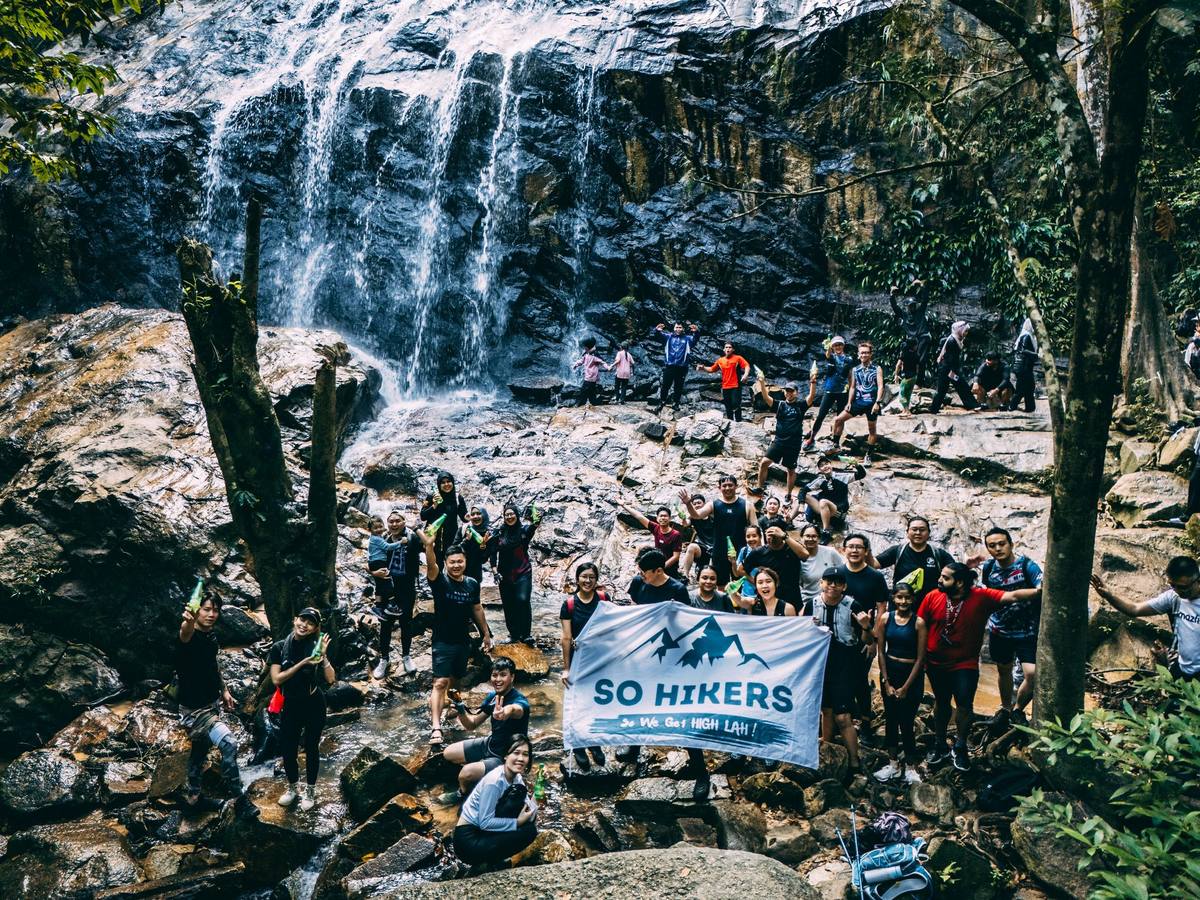 Waterfall group photo with SO HIKERS flag