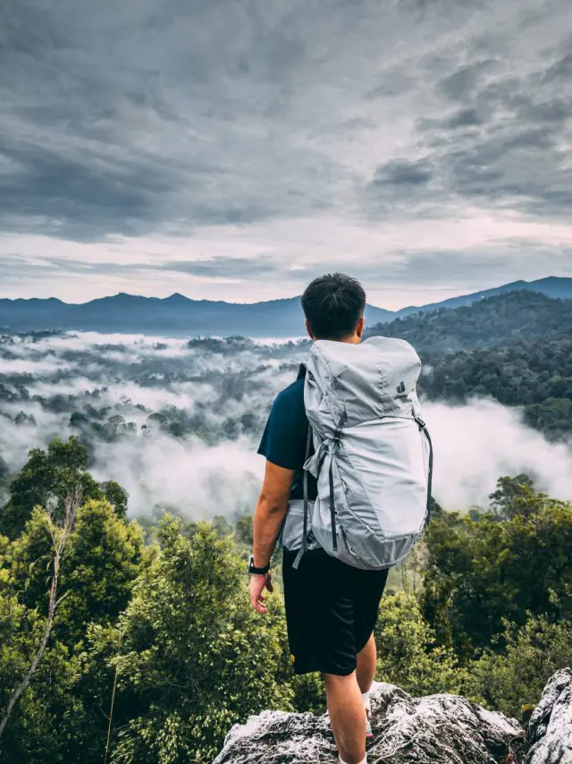 Hiker overlooking misty valley with Deuter pack