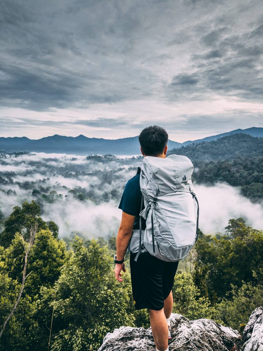 Hiker overlooking misty valley with Deuter pack