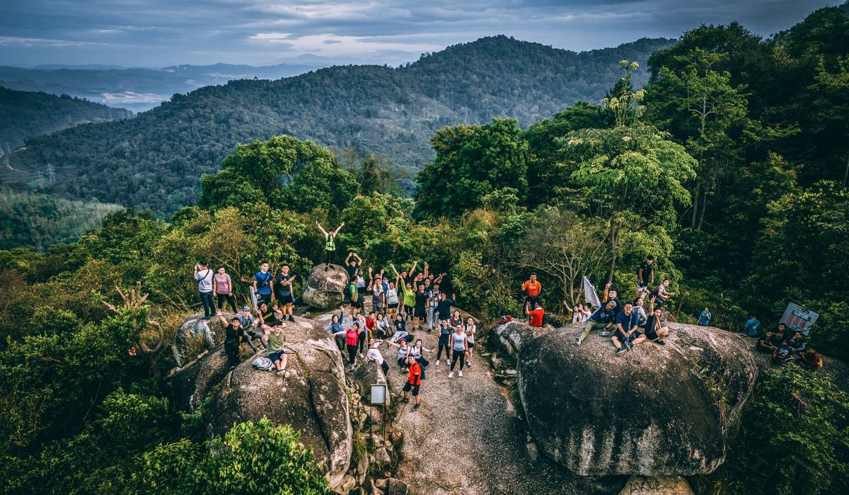Drone shot of group on rocky boulders with forest valley