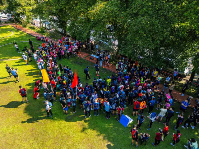 Aerial drone shot of large crowd on grass field