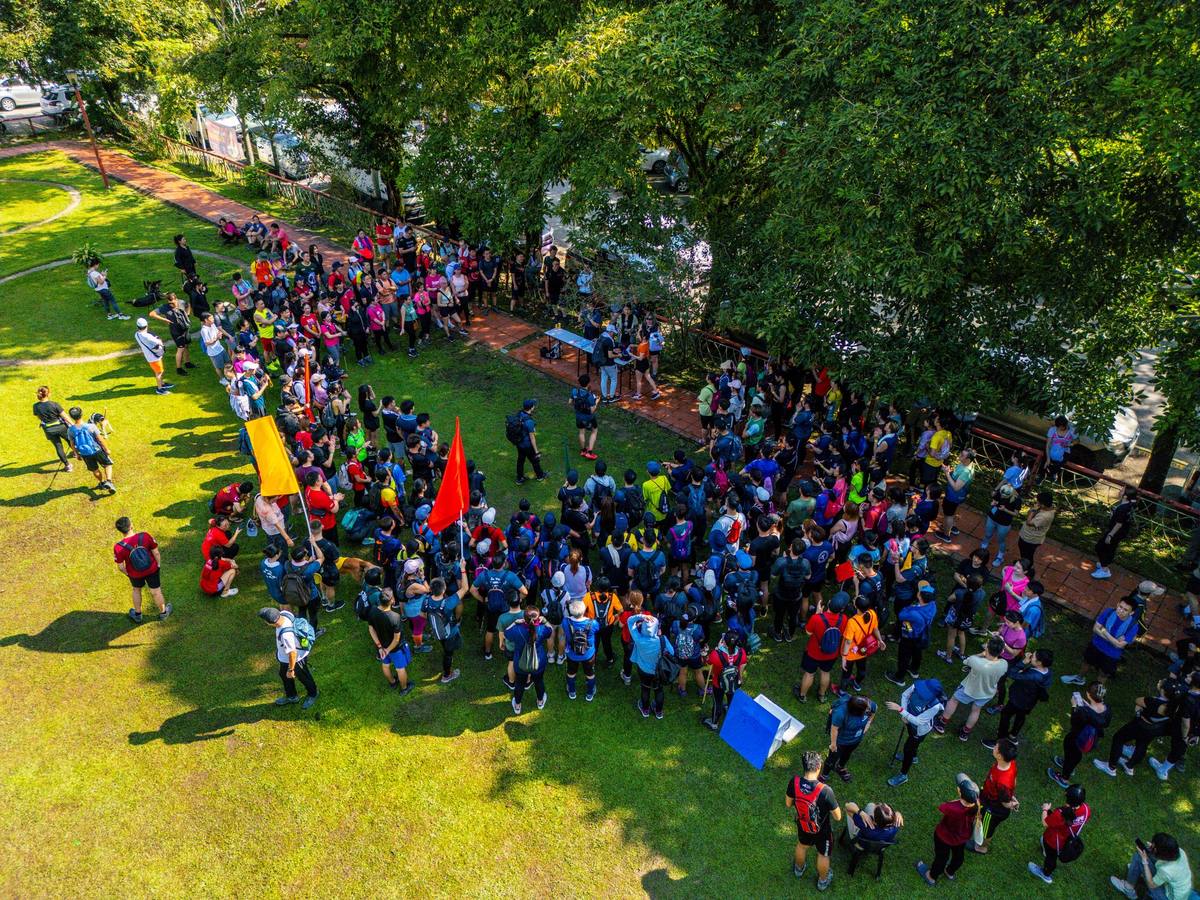 Aerial drone shot of large crowd on grass field