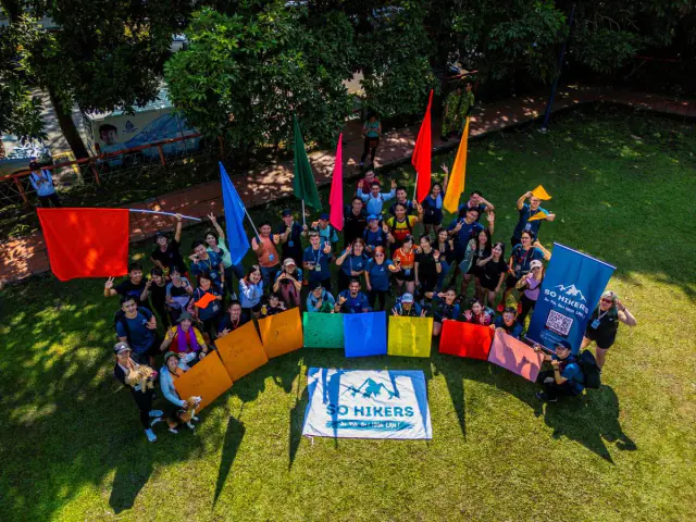Aerial group photo with colourful flags on field