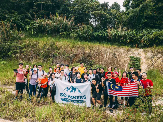 Group with So Hikers flag and Malaysian flag on open trail