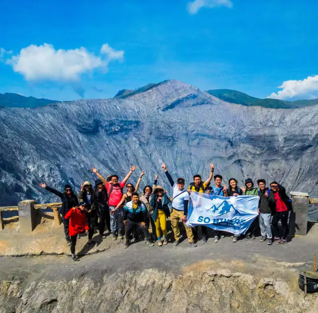 Large group with So Hikers flag at palm tree road