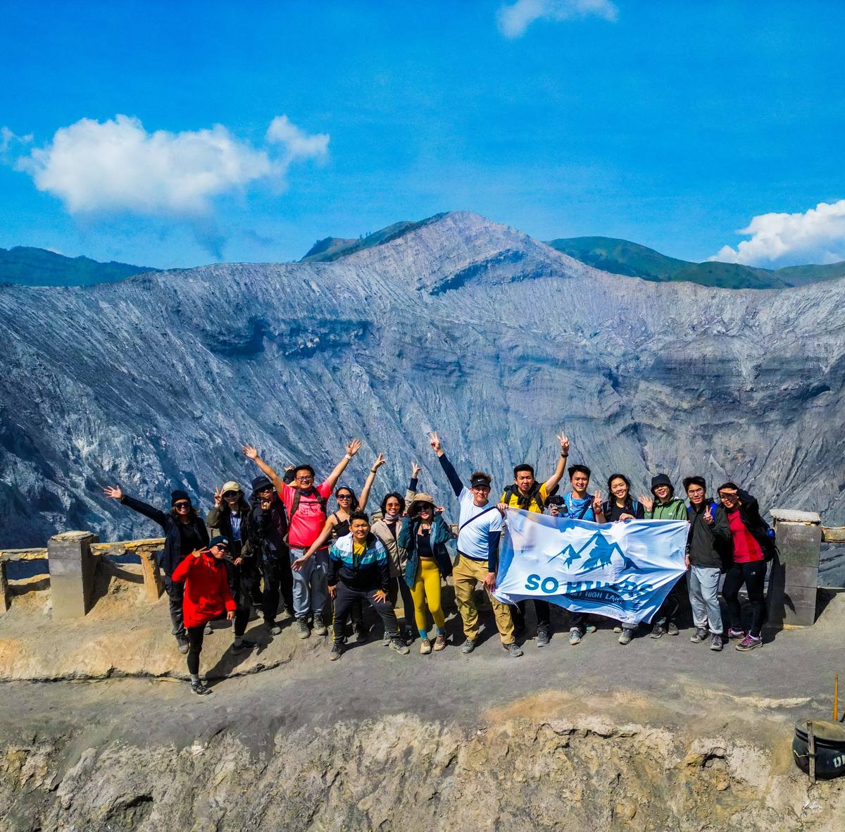 Large group with So Hikers flag at palm tree road