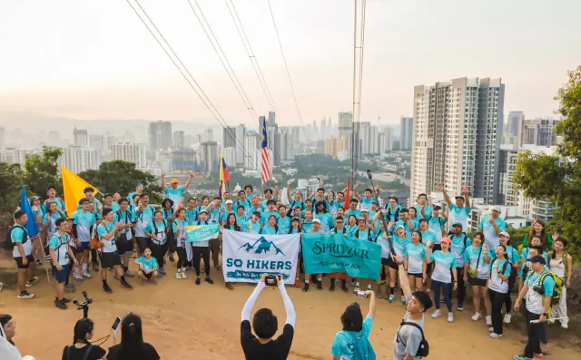 So Hikers x Spritzer group at the summit with KL city skyline and Malaysian flag