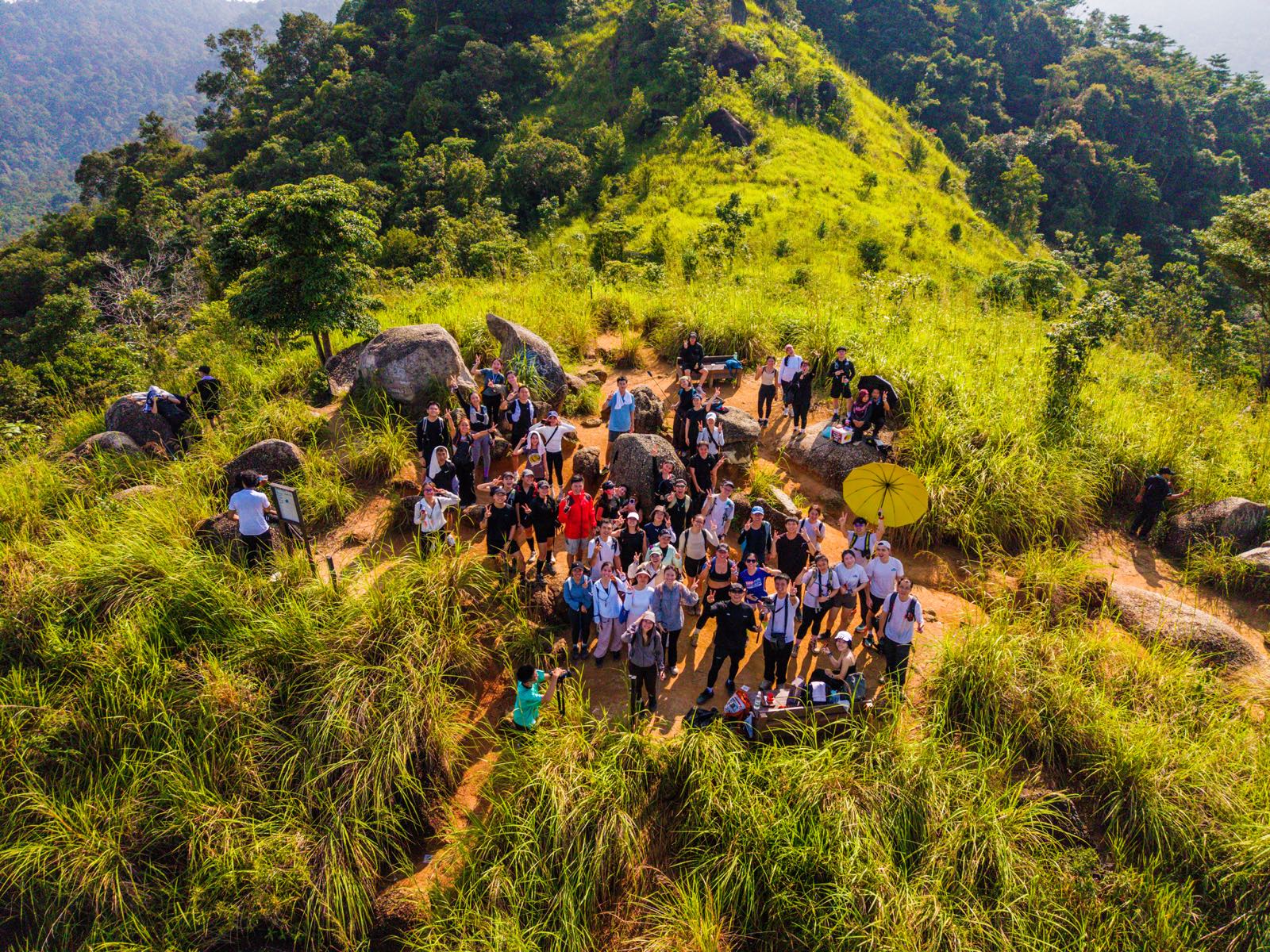 Aerial drone shot of the So Hikers group on a green hilltop
